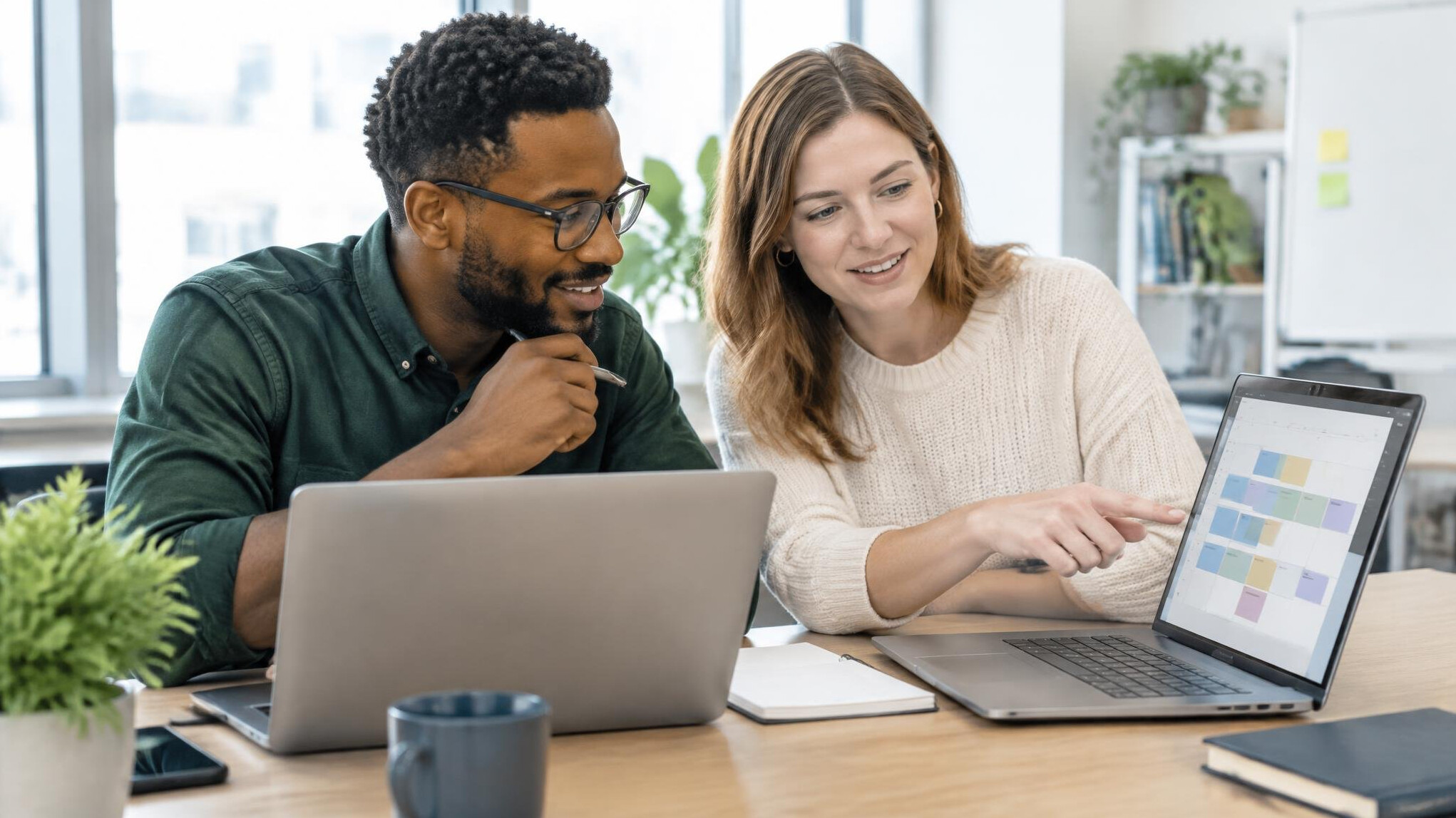 Colleagues working together at laptops in an office